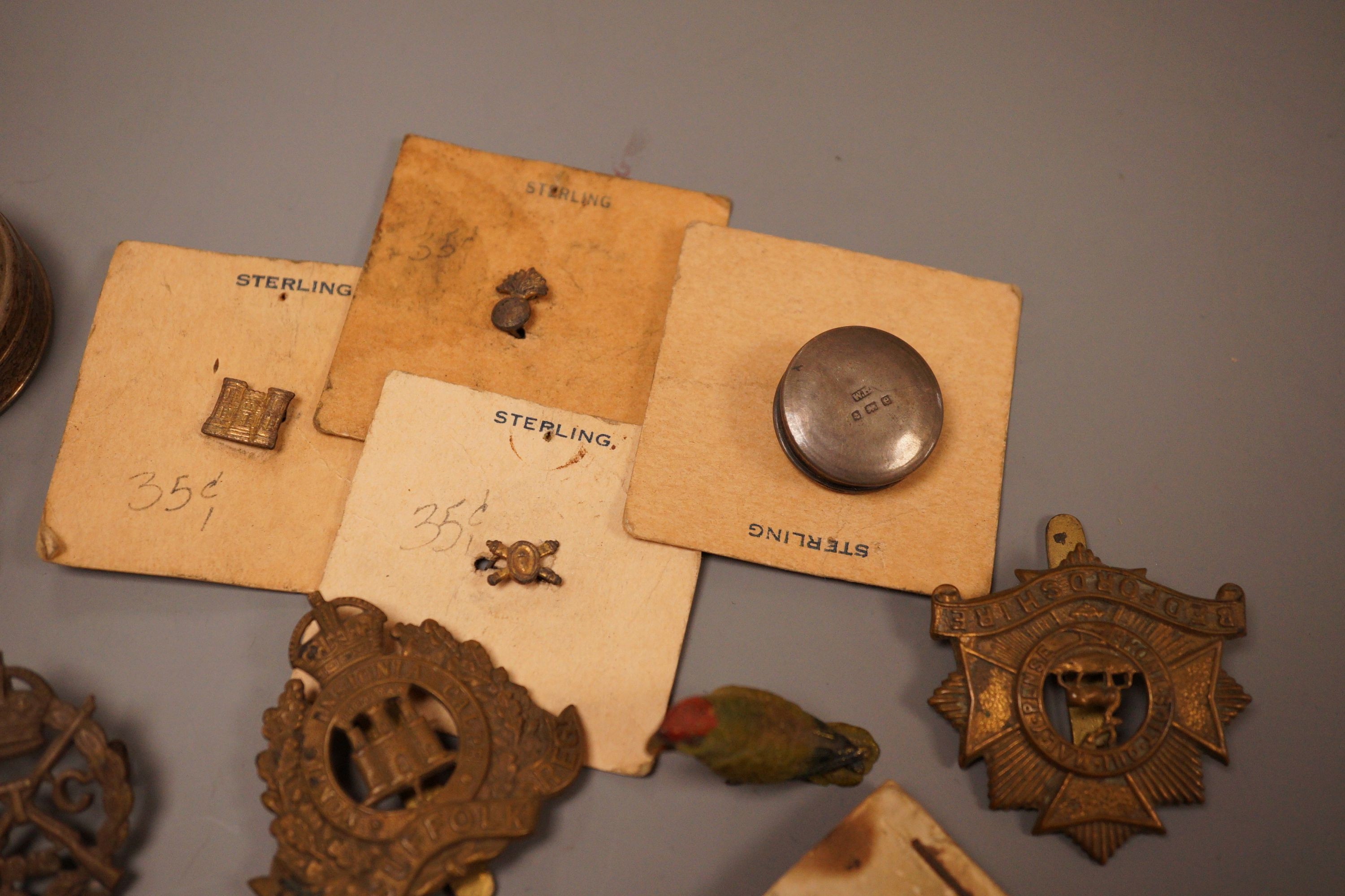 A selection of various miscellaneous items, to include a George III silver vinaigrette, a military pin badge, an Edwardian flick book, a cold painted parrot, and others.